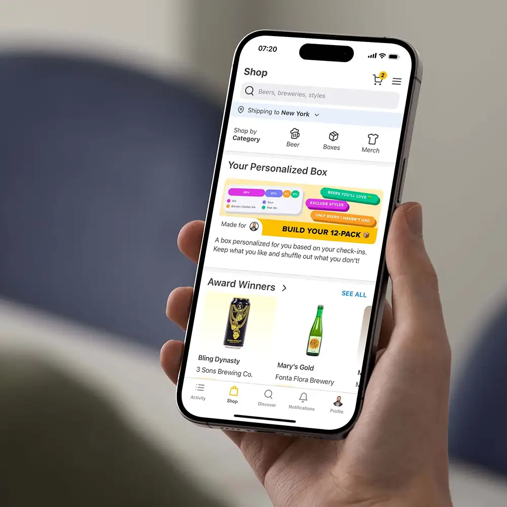 A user holding their phone with the Untappd Shop displayed within the Untappd app